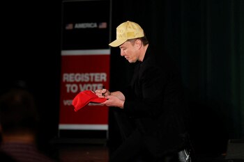Elon Musk firma una gorra