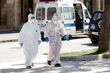 Trabajadores de salud visten trajes