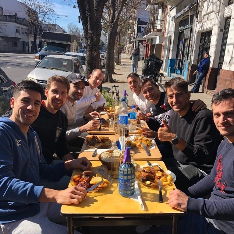 La selección argentina de futsal disfrutó de su carne al horno con una mesa larga en la vereda del bodegón