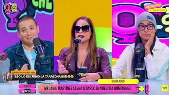 Tres personas sentadas en un panel de televisión. Una mujer en el centro con gafas de sol y chaqueta de cuero habla en un micrófono, flanqueada por un hombre y otra mujer