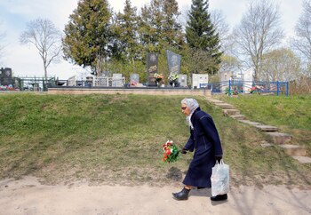 Una anciana visita el cementerio