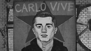 Mural monocromático en pared de ladrillos con el retrato de un hombre, el texto "CARLO VIVE" y una estrella de cinco puntas