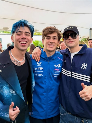 Luck Ra con cabello azul, Franco Colapinto con chaqueta Alpine y Bizarrap con gorra negra y gafas posan en el Road Show Buenos Aires, sonriendo a cámara