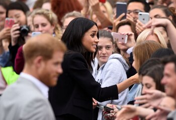 Imagen de archivo del príncipe Enrique de Reino Unido y Meghan, duquesa de Sussex, estrechando las manos de miembros de la multitud durante una caminata en la Plaza del Parlamento en Trinity College, Dublín, Irlanda. 11 de julio, 2018. REUTERS/Clodagh Kilcoyne/Archivo