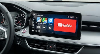 Interior de un vehículo con una pantalla central que muestra la interfaz de Android Auto, destacando los iconos de YouTube, Google Maps y otras aplicaciones.