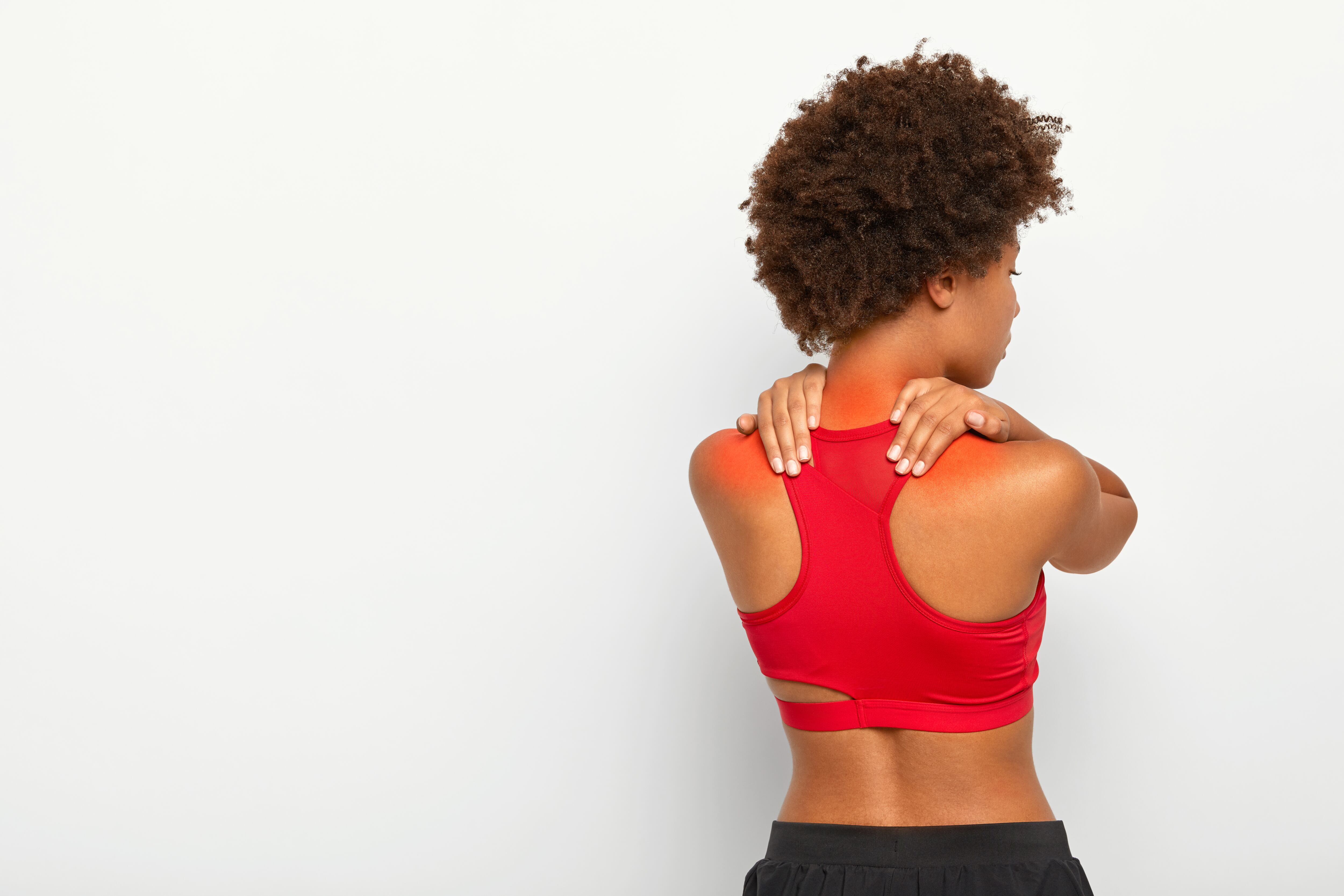 Una mujer sufre una contractura muscular en la zona del cuello y los hombros (Freepik)
