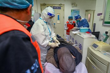 Un médico del centro de rescate de emergencia de Chaoyang explica las condiciones de un paciente al personal del hospital a su llegada a través de una ambulancia, en medio del brote de la enfermedad por coronavirus (COVID-19) en Beijing, China 29 de diciembre de 2022. cnsphoto via REUTERS