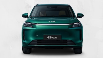 Vista frontal de un SUV DFSK E5 Plus de color verde, con faros y una tira de luz LED horizontal, sobre un fondo blanco