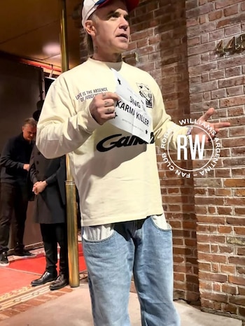 Robbie Williams sorprendió a sus fans con un show acústico en la puerta de su hotel