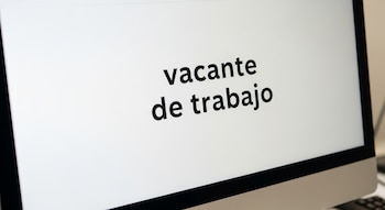 Primer plano de una pantalla de computadora con el texto en español "vacante de trabajo" en letras negras sobre un fondo blanco.