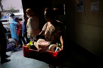 Una vendedora ambulante, que pasó a vivir en la calle tras no poder seguir pagando su alquiler, arriba a una escuela que se utiliza como refugio temporal en medio de la propagación del COVID-19 en Tegucigalpa, Honduras, el 30 de abril de 2020 (REUTERS/Jorge Cabrera)