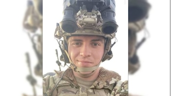 Primer plano de un militar con uniforme de camuflaje y casco táctico equipado con visor nocturno y sistema de comunicación