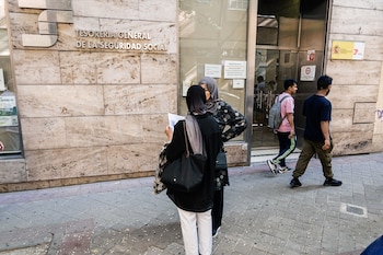 Varias personas migrantes esperan en el exterior de una oficina de la Seguridad Social en Madrid. (Carlos Luján / Europa Press)
