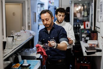 Un camarero limpia una copa