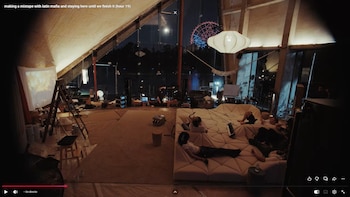Captura de pantalla de un ordenador personal con video de un estudio de música nocturno, personas, sofá, equipos de sonido y una rueda de la fortuna
