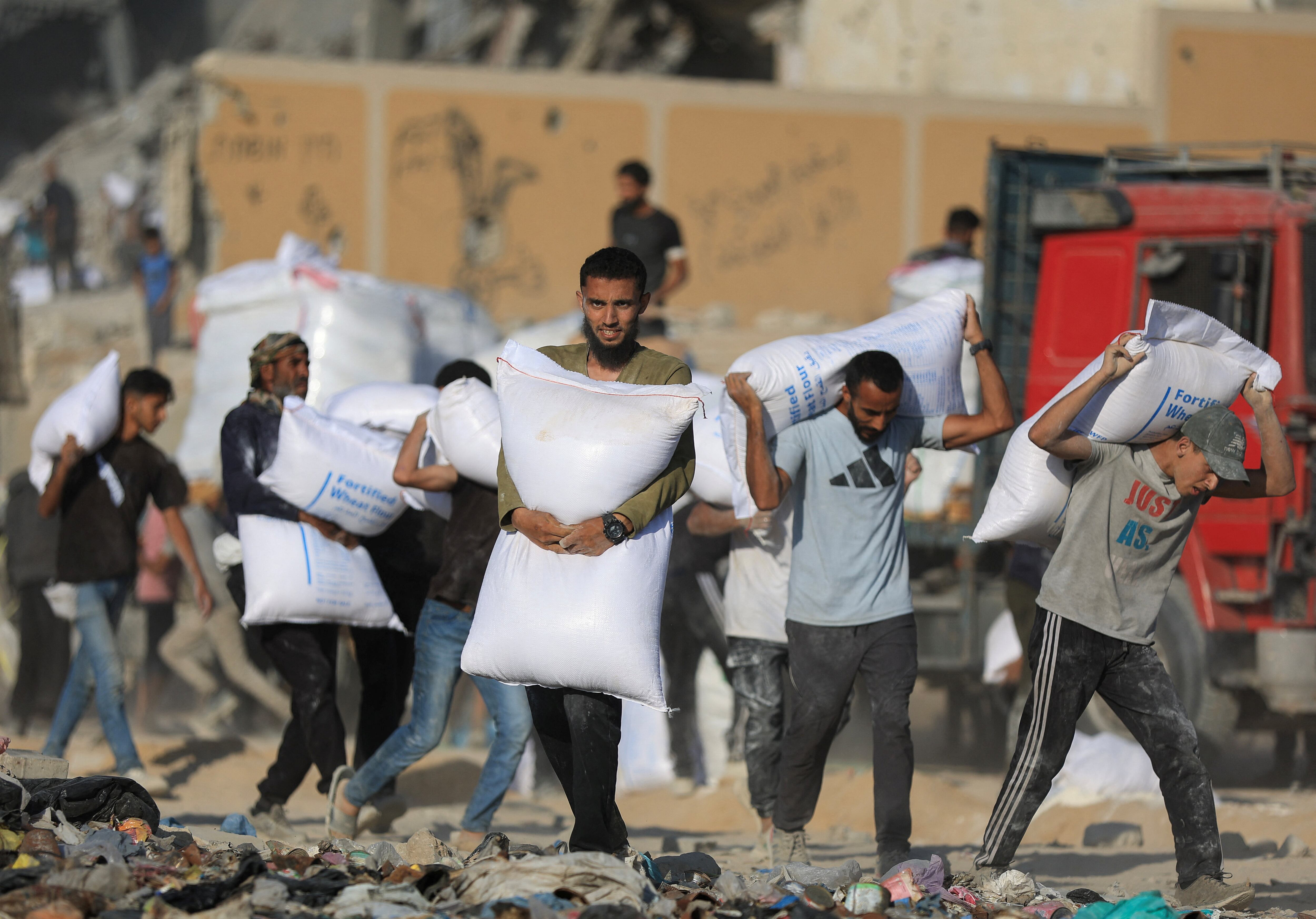 Palestinos transportan suministros de ayuda en Beit Lahia, en el norte de la Franja de Gaza, el 25 de junio de 2025 (REUTERS/Dawoud Abu Alkas)