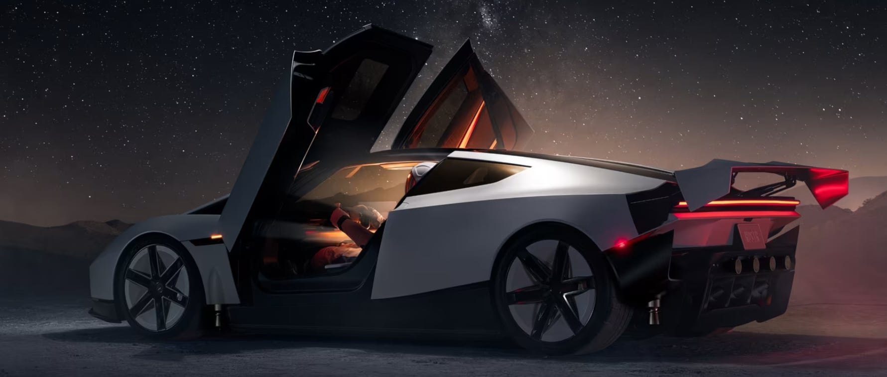 El automóvil eléctrico Tesla Roadster se presenta con las puertas abiertas en un escenario nocturno bajo el cielo estrellado. (Tesla)
