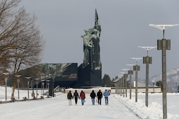 Personas caminan hacia un monumento