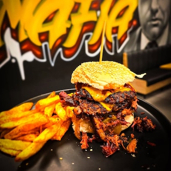 Frank Lucas Burger de brisket ahumado nueve horas, salsa BBQ de miel, aros de cebolla caramelizada y cheddar en pan tostado