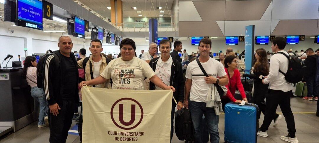 Fabián Bustos y su comando técnico junto a un hincha de Universitario previo a su viaje a Paraguay.