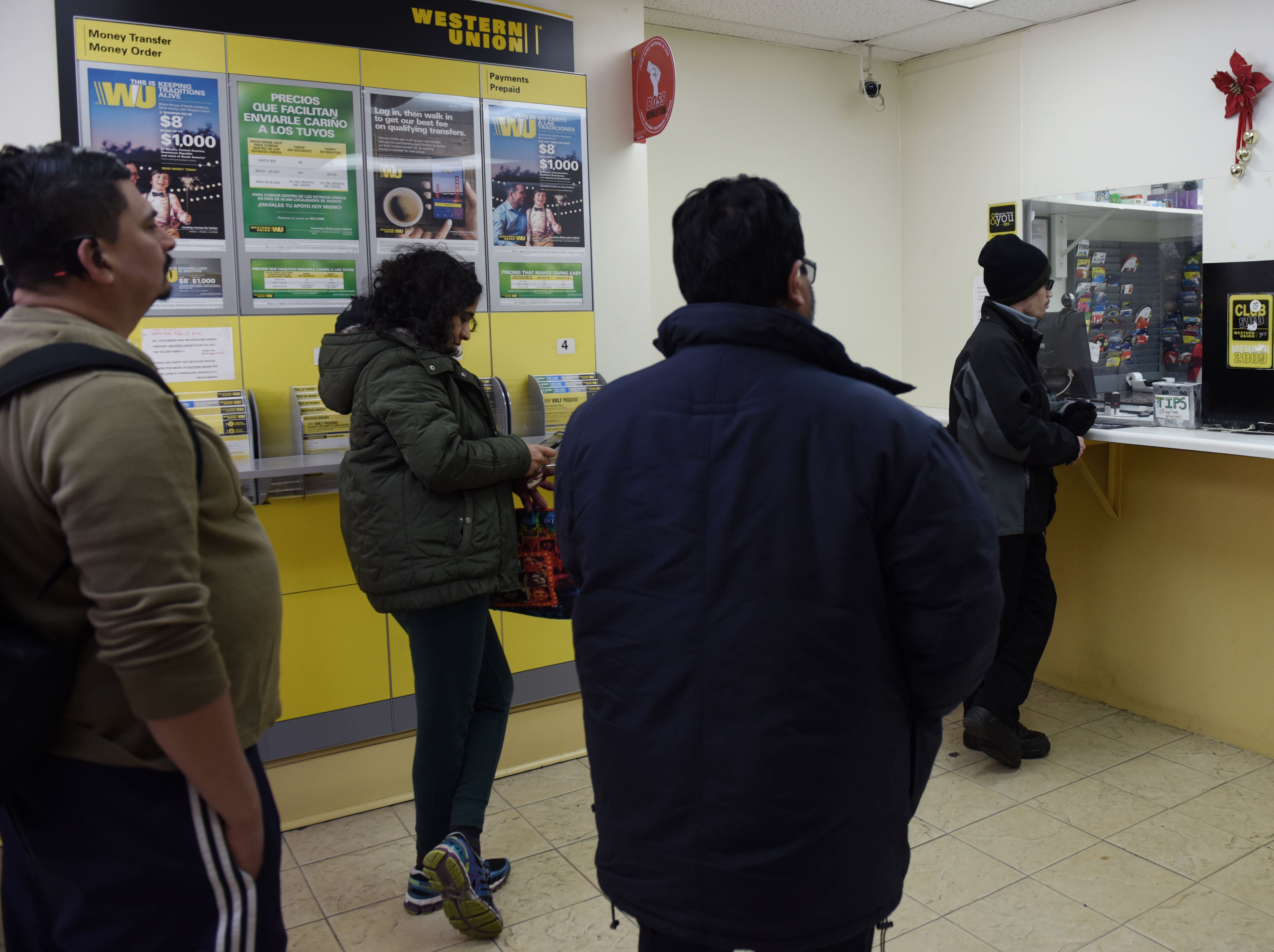 Varias personas esperan su turno para enviar dinero a sus países de origen. Fotografía de archivo. EFE/Lenin Nolly