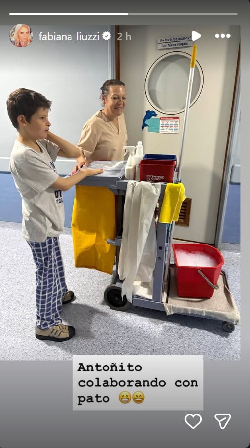 Antonio, el hijo de Fabiana Liuzzi y Luis Ventura, colabora con una trabajadora de limpieza junto a un carro de mantenimiento durante su internación.