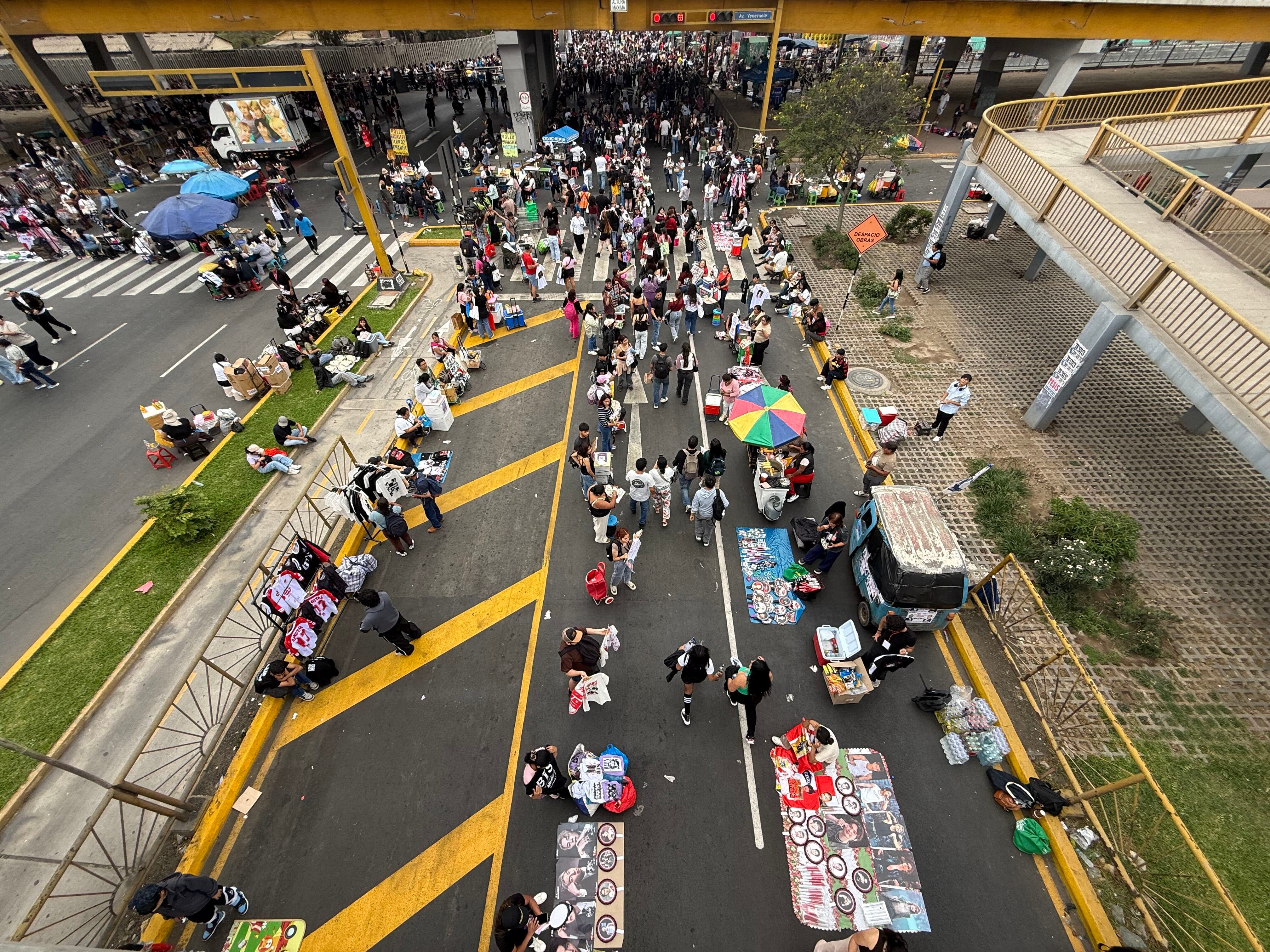 Seguidores del grupo BTS y comerciantes ambulantes se concentran en las inmediaciones del Estadio San Marcos en Lima. (Paula Díaz)