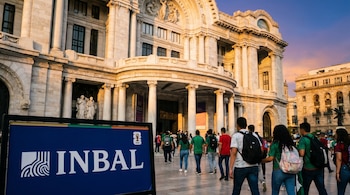 La fachada del Palacio de Bellas Artes se ilumina al atardecer. Un cartel azul con el logo del INBAL y el Mundial 2026 en primer plano, con personas pasando.