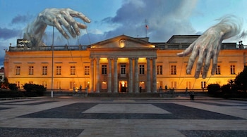 Pintura estilo óleo de la Casa de Nariño en Bogotá, con dos grandes manos de títere fantasmales que parecen controlar el edificio.