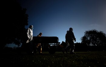 Trabajadores funerarios trasladan el féretro de una persona muerta por covid-19. EFE/ Juan Ignacio Roncoroni/Archivo