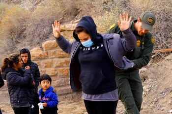 A migrant who was detained with others by U.S. Border Patrol agents inside a tunnel after crossing into the United States from Mexico is checked, in Sunland Park, New Mexico, U.S. March 23, 2023. REUTERS/Jose Luis Gonzalez