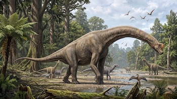 Un gran dinosaurio de cuello largo camina por un bosque con árboles altos, un río, helechos y reptiles voladores en el cielo.