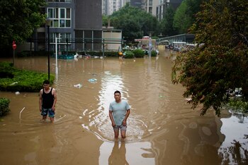 Personas atraviesan las inundaciones cerca