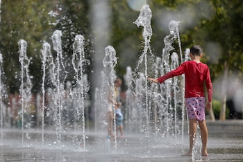 Un niño se refresca en una fuente durante este miércoles. (Ana Escobar/EFE)
