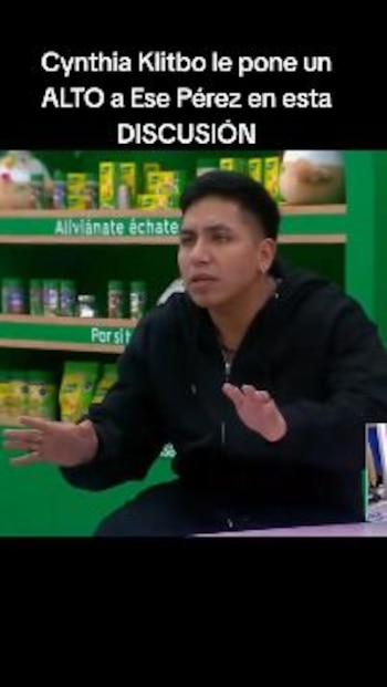 Hombre con sudadera negra y manos extendidas, sentado. Fondo verde con estanterías y productos. Texto blanco en la parte superior