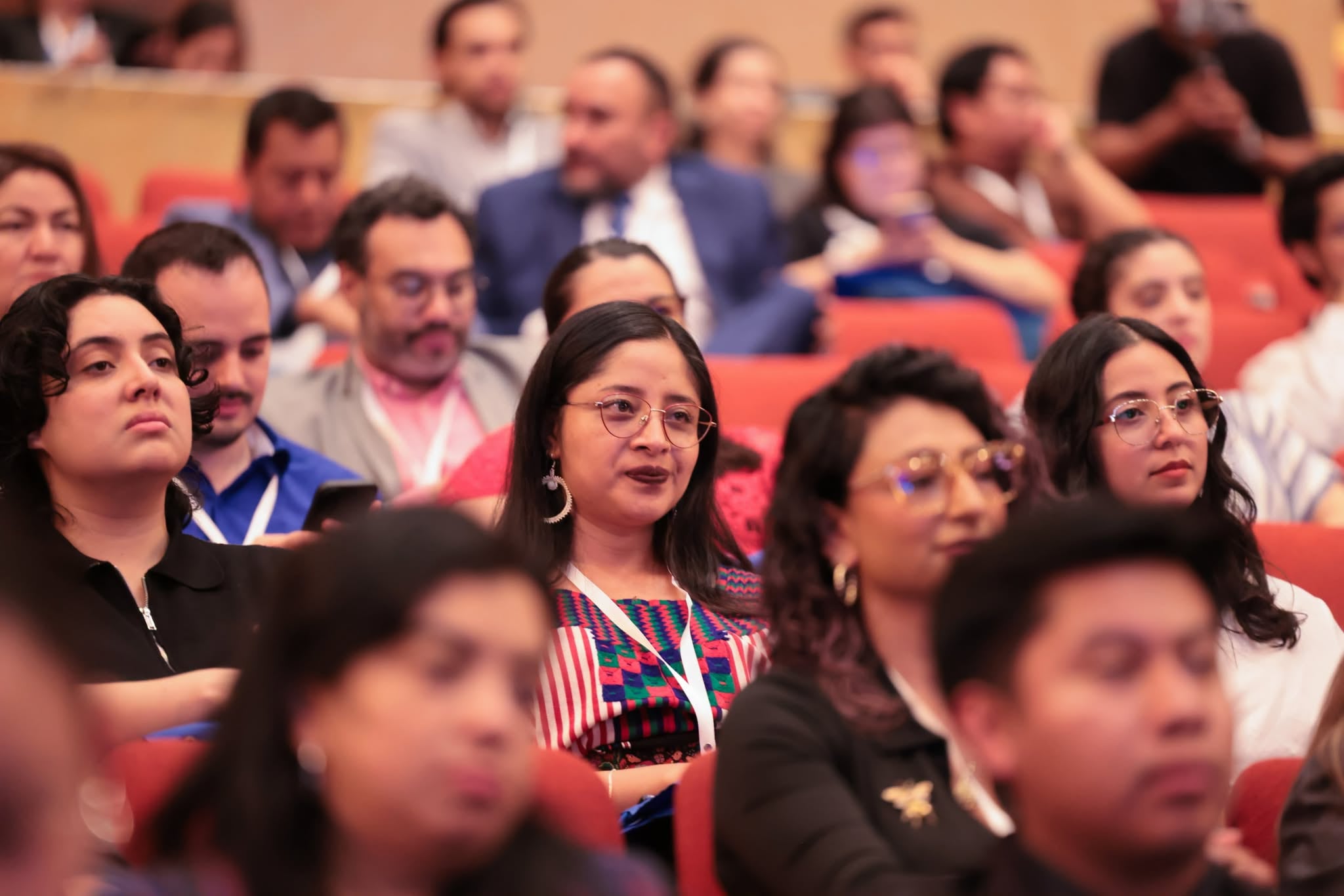 Tres ponentes participan en el evento AbreLatam ConDatos sobre el escenario de un teatro en Guatemala. (Ministerio de Finanzas de Guatemala)