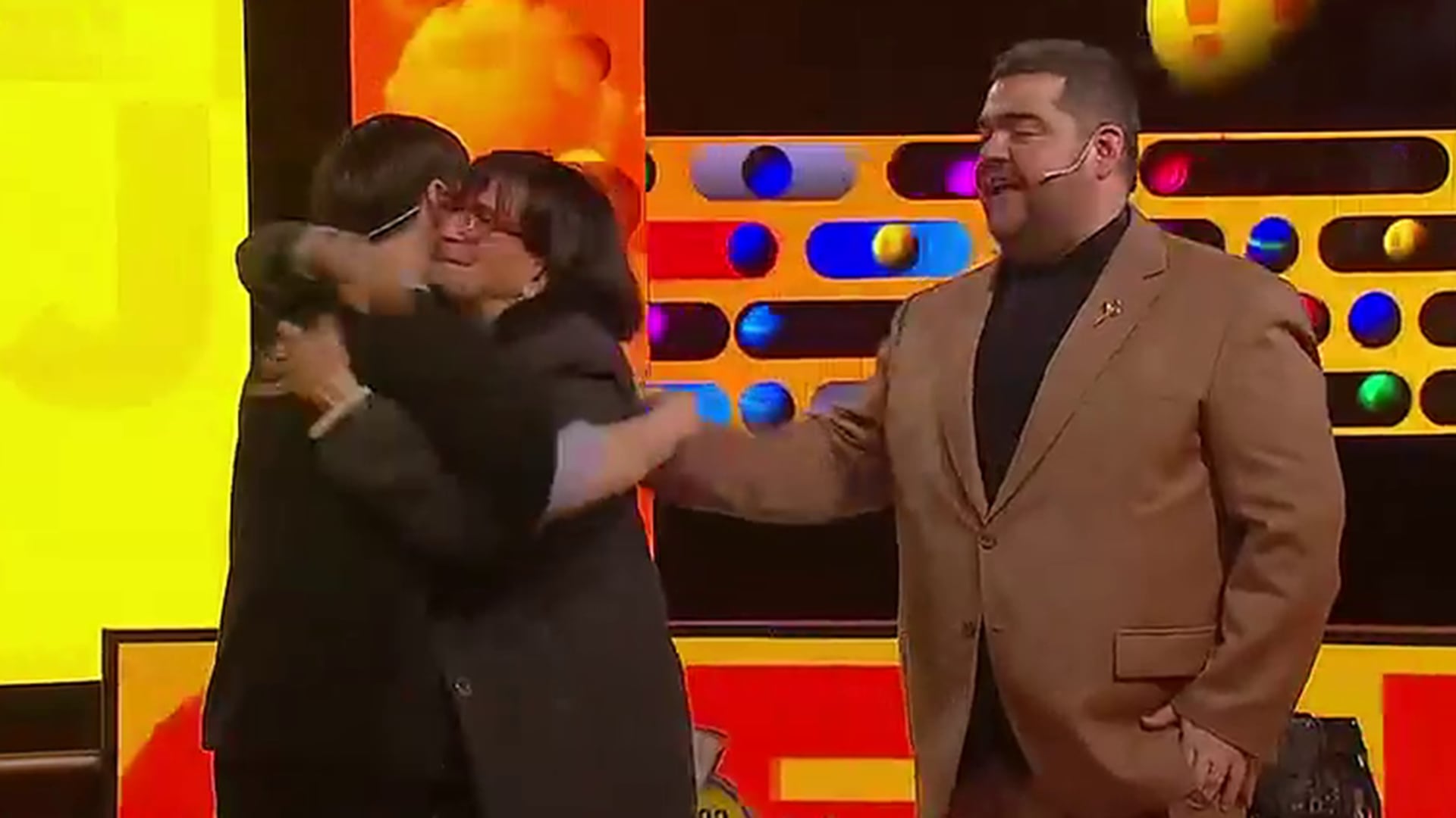 El conductor Darío Barassi presencia el abrazo entre el participante ganador de Ahora Caigo y su madre tras obtener el premio final.