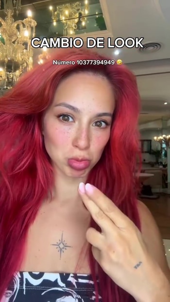 Flor Vigna en primer plano con cabello rojo vibrante y largo, haciendo una mueca con los labios fruncidos y mostrando un tatuaje de estrella en el pecho