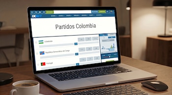Pantalla de laptop con página web de apuestas deportivas "Partidos Colombia" de 1xBET, mostrando partidos de Uzbekistán, Congo y Portugal, con cuotas.