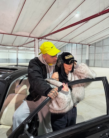 La pareja, a bordo de un auto descapotable, con gorras