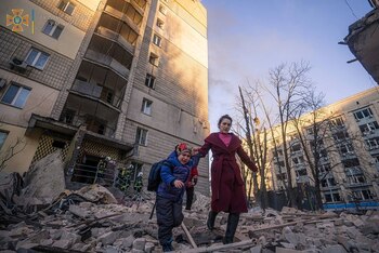 Una mujer con un niño evacua de un edificio residencial dañado por los bombardeos, mientras continúa el ataque de Rusia a Ucrania, en Kiev, Ucrania, en esta imagen de mano publicada el 16 de marzo de 2022. Servicio de prensa del Servicio Estatal de Emergencias de Ucrania/Handout via REUTERS