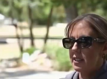Primer plano del rostro de una mujer con gafas de sol oscuras al aire libre con vegetación desenfocada al fondo
