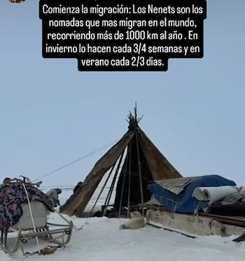 Vista de un campamento Nenets en la tundra nevada, con una tienda cónica, trineos cargados de pertenencias y una figura animal blanca en primer plano