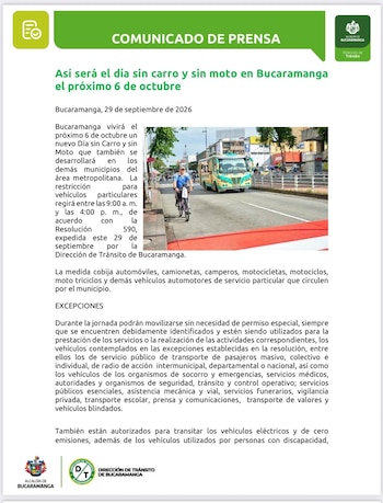 Un automóvil gris y dos motocicletas avanzan por una calle asfaltada con barreras amarillas, edificios y árboles al fondo