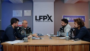 Cuatro hombres sentados alrededor de una mesa de madera con micrófonos y tazas en un estudio de pódcast con el logotipo LFPX