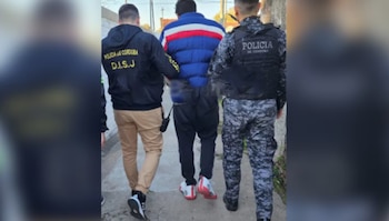 El detenido es escoltado por