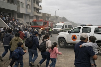 Personas evacuan edificios en Ica, caminando por la calle. Se ven vehículos de bomberos, ambulancia y camioneta de Defensa Civil Perú con logo naranja triangular.
