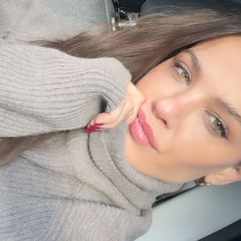 Ivana Figueiras posa para un retrato de cerca, mostrando su cabello castaño y suéter de cuello alto en tono gris.