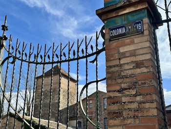 Una señal en una columna de ladrillo al lado de la verja que da entrada de la Colonia Antius, en Bages (Barcelona). (LM Finques)