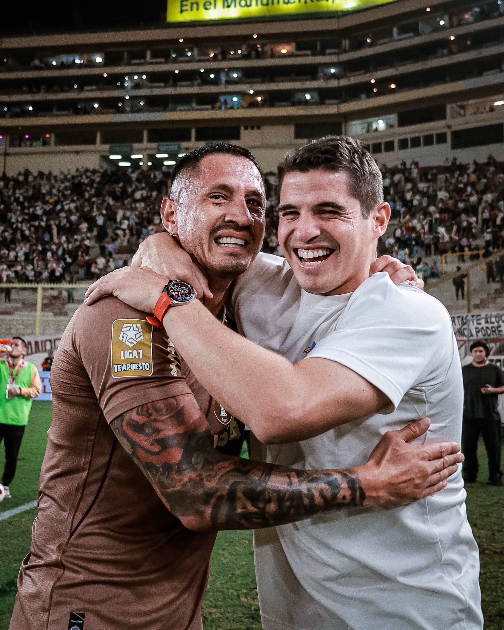 Gianluca Lapadula y Aldo Corzo comparten un abrazo de celebración tras la victoria de Universitario 2-1 contra Cusco FC en la Liga 1 2026. (Liga 1 / @iteasport_)